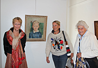 Eva Rosenqvist, Marianne Thaning and Anna-Stina Thaning in front of the portrait of Gunnar Thaning